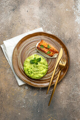 Pan seared white fish fillet with edamame puree on rustic background