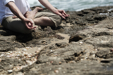 Yoga lesson. A man practices yoga near the sea.