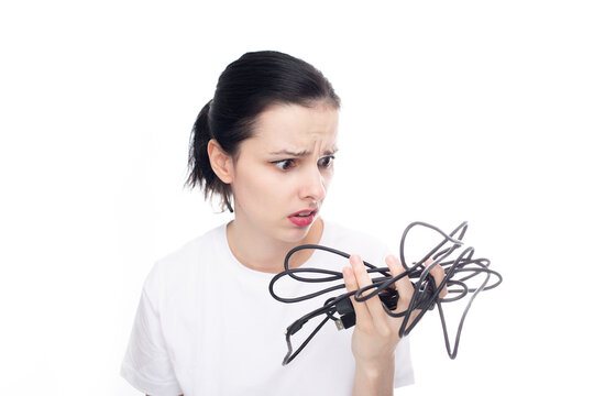 Upset Woman In A White T-shirt Holding A Wire In Her Hand, White Background