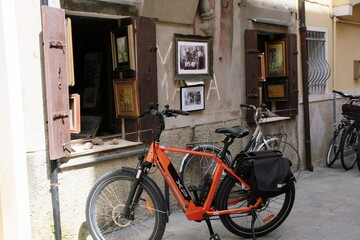 Fototapeta na wymiar Bicicletas aparcadas frente a fachada antigua de exhibición de pinturas y fotos.