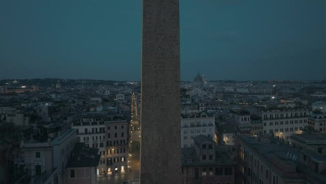 Aerial view closely around the Obelisco Sallustiano revealing the Spanish steps, night in Rome, Italy - circling, drone shot