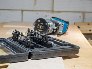 black plastic case of carbon steel tempered router bits with cordless hand trimmer router