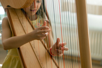 The child plays the harp. Selective focus.
