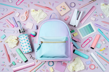 School backpack with stylish stationery on pink background. School stationery or office supplies....
