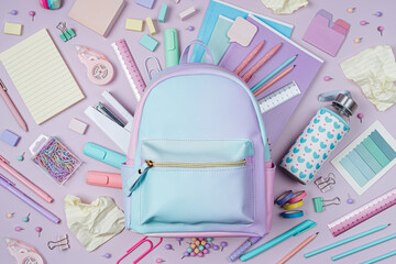 Opened School backpack with stationery in pastel color on pink background. Concept back to school....
