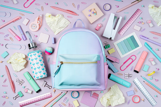 School backpack with stylish stationery on pink background. School stationery or office supplies. Concept back to school.