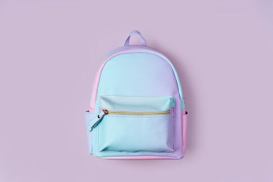 School backpack in pastel color on pink background. Concept back to school.