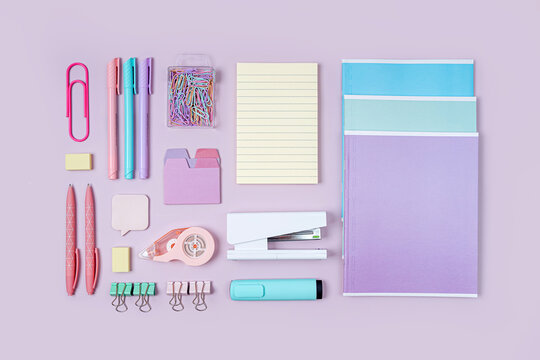 Stylish stationery is arranged neatly on pink background. School stationery or office supplies. Workplace organization