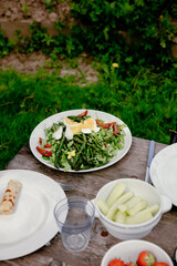 A plate with asparagus on a wooden lunch table outside 