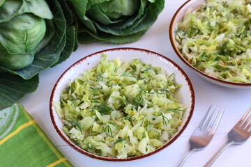Stewed young cabbage sprinkled with chopped dill. Spring vegetable dishes. Vegetarian cooking
