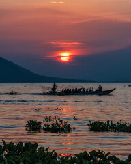 Naklejka premium Fishing under a full round sun during a beautiful sunset