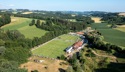 Drone view of a mountain landscape in Pregarten Austria with a football field. Football field among Tirol fields and alpine mountains