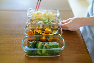 A woman who puts prepared side dishes on a plate