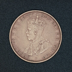 Obverse side of an Australian one penny coin coin from 1932, made of bronze and featuring King George V, on a black surface