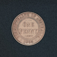 Reverse side of an Australian one penny coin coin from 1932, made of bronze, on a black surface
