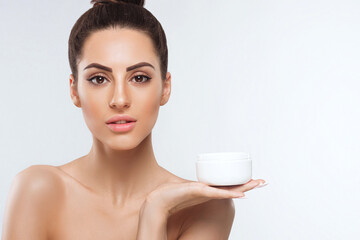 Skin care.Beautiful Young Woman with Clean Fresh  Skin Holding Bottle cream. Beauty face care....