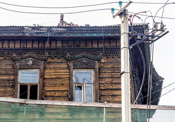 Old ruined house with carved architraves and broken glass in the windows - obrazy, fototapety, plakaty