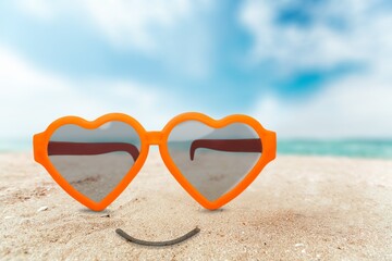 Fototapeta na wymiar Sunglasses on beach sand with sea. The concept of a positive and successful holiday.