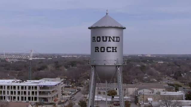 Aerial pan around of silver water tower in Round Rock, Texas on a sunny day.