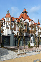 Obraz premium The monument to Lenin stands against the background of a beautiful European-style house among trees without foliage in Zelenogradsk, Kaliningrad region, Russia, near the Baltic sea.