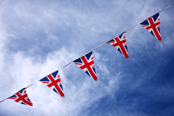 UK Union jack bunting flags in blue sky celebrating british culture
 - obrazy, fototapety, plakaty