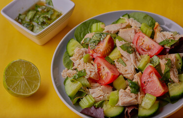 Fresh cooked chicken with mixed salad and dressed with lime juice and herbs. 
