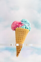 Bubble Gum and Cotton Candy Ice Cream on Waffle Cone With Clouds in Background - 505716950