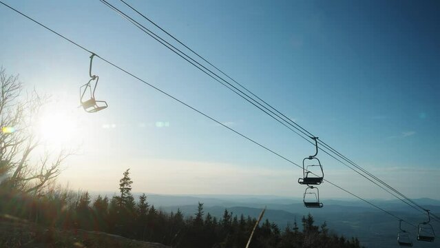 Sunset with chairlifts on ski mountain during spring summer with mountain skyline 4k 30p