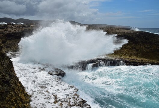 Seascape at the north west shore of Curacao at the Boka Pistol in the Shete Boka National park,
huge wave crashing onto the cliff with a big splash