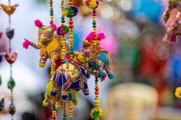 Handmade colorful rajasthani puppets hanging on blue colour wall for décor. Selective focus on...