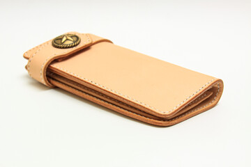 Women's long leather wallet in neutral leather tone isolated on a white background