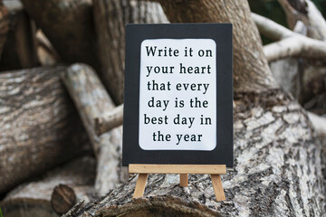 Motivational and inspirational quote on a chalkboard isolated on tree trunk.