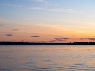 Fototapeta na wymiar Colorful backdrop. Sea landscape. Blue sky. Sunset on the river.