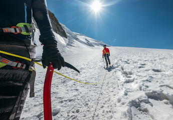 Rope team descending Mont Blanc (Monte Bianco) summit 4,808m dressed mountaineering clothes walking...