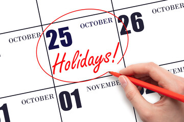 Hand drawing a red circle and writing the text Holidays on the calendar date 25 October. Important...