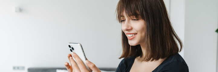 Smiling young woman using mobile phone