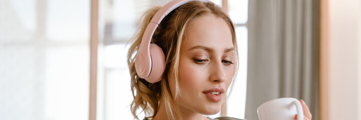 Young woman listening music with cellphone and headphones at home
