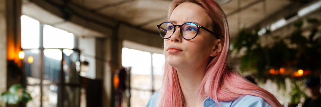 Young Beautiful Woman With Pink Hair Doing Paperwork In Cafe