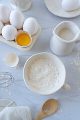Fototapeta na wymiar Huevos, azúcar, leche, harina, preparación, receta, pastel, ingredientes, cocinar, mármol, pastelería.