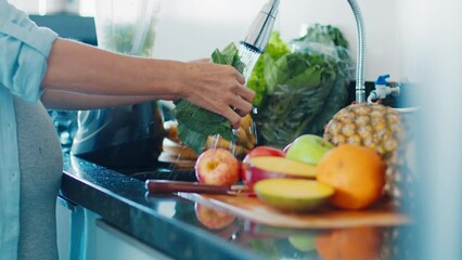 Pregnant diet. Pregnant woman washes fruits and prepares healthy cocktail on the modern kitchen - Powered by Adobe