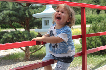 sad and unhappy child boy in the street is crying.