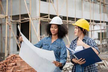 The engineer manager and female foreman are standing on the construction site to check the various...