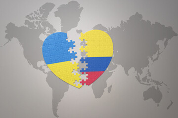 puzzle heart with the national flag of ukraine and colombia on a world map background. Concept.