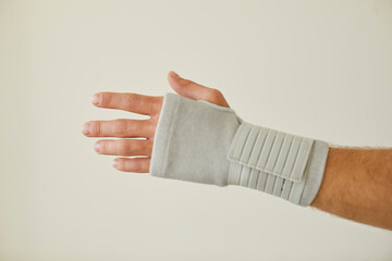 Male patient with tendonitis wears orthopaedic wrist brace. Cropped close up of human hand in...
