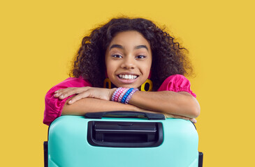 Studio shot of happy child with suitcase. Portrait of cheerful kid with travel bag. Beautiful...