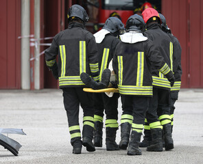 group of firefighters who help the injured person after the road accident and transport him on a...