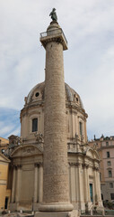Fototapeta na wymiar Roman Trajans Column with a high relief and the Church of the Most Holy Name of Mary at the Trajan Forum