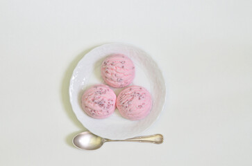 Top view of three scoops of Strawberry ice cream on white Plate