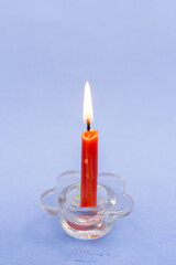 a small orange candle burns on a blue background