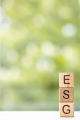 ESG - word is written on wooden cubes on a green summer background. Close-up of wooden elements.